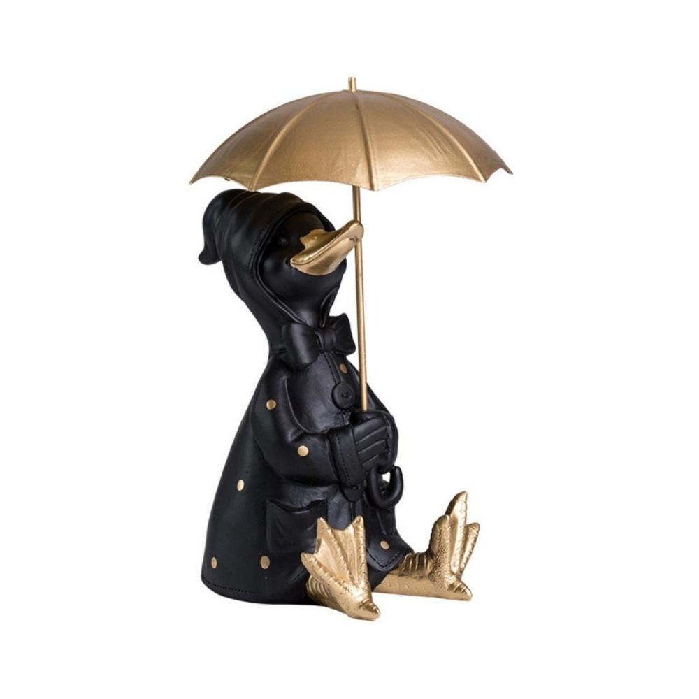 Μία καθιστή διακοσμητική πάπια με ανοιγμένη χρυσή ομπρέλα