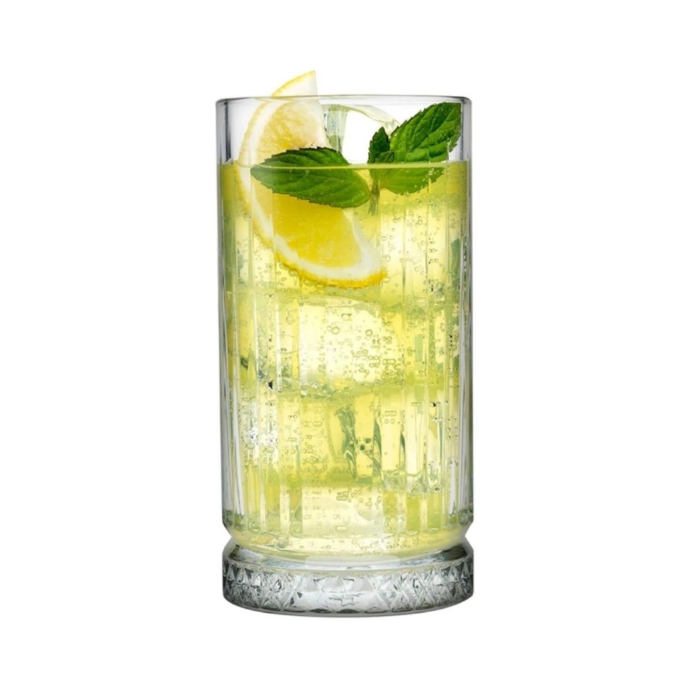 Ένα γεμάτο γυάλινο ποτήρι με κίτρινο ποτό, λεμόνι και δυόσμο