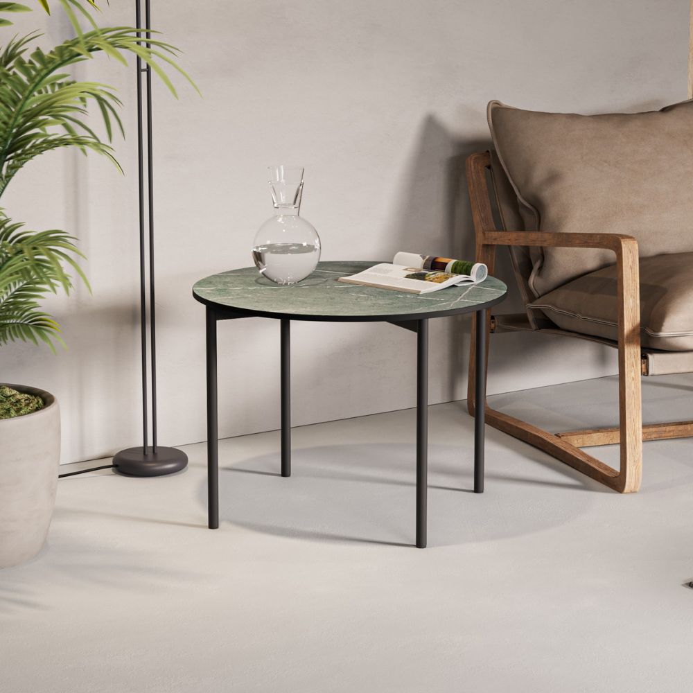 Μία μεταλλική βάση για βοηθητικό τραπεζάκι σαλονιού σε μαύρο χρώμα σε λευκό σαλόνι