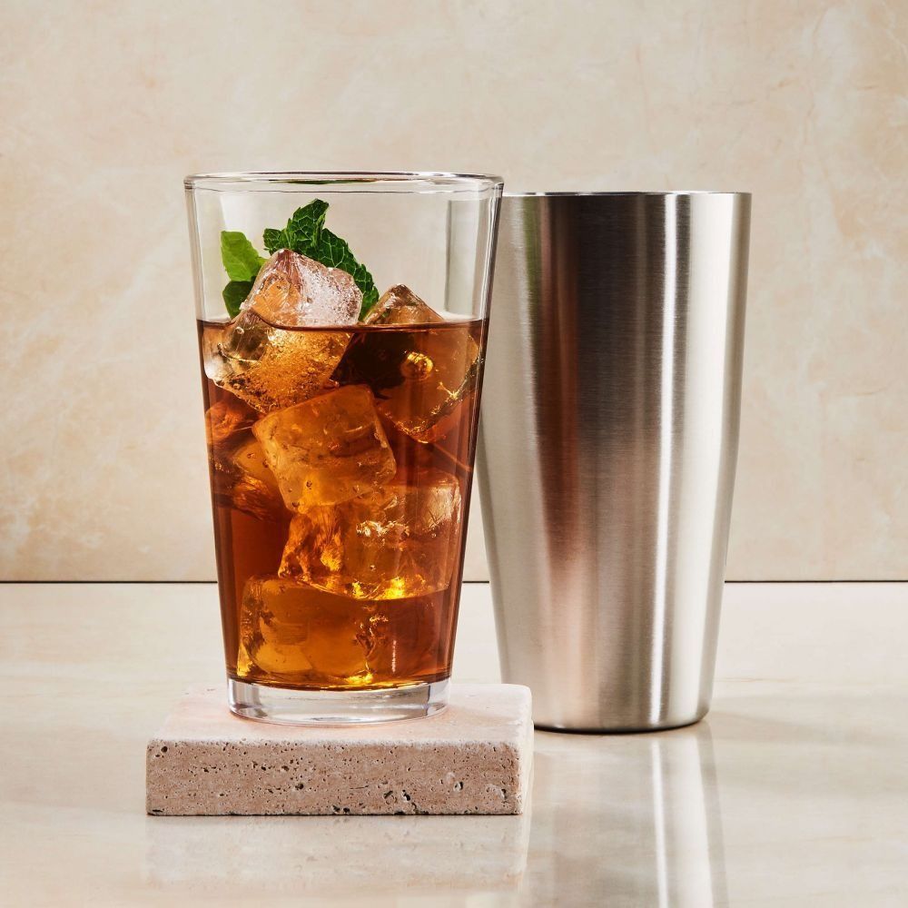 Ένα σέικερ με ένα γυάλινο ποτήρι γεμάτο με πότο